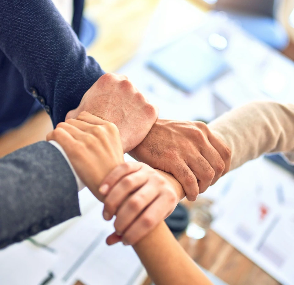 team members gripping wrists in unity gesture